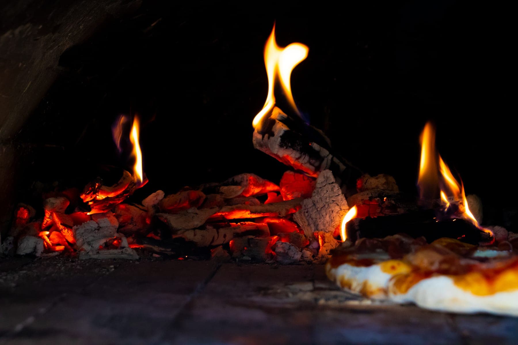 Charcoal glowing inside a pizza oven