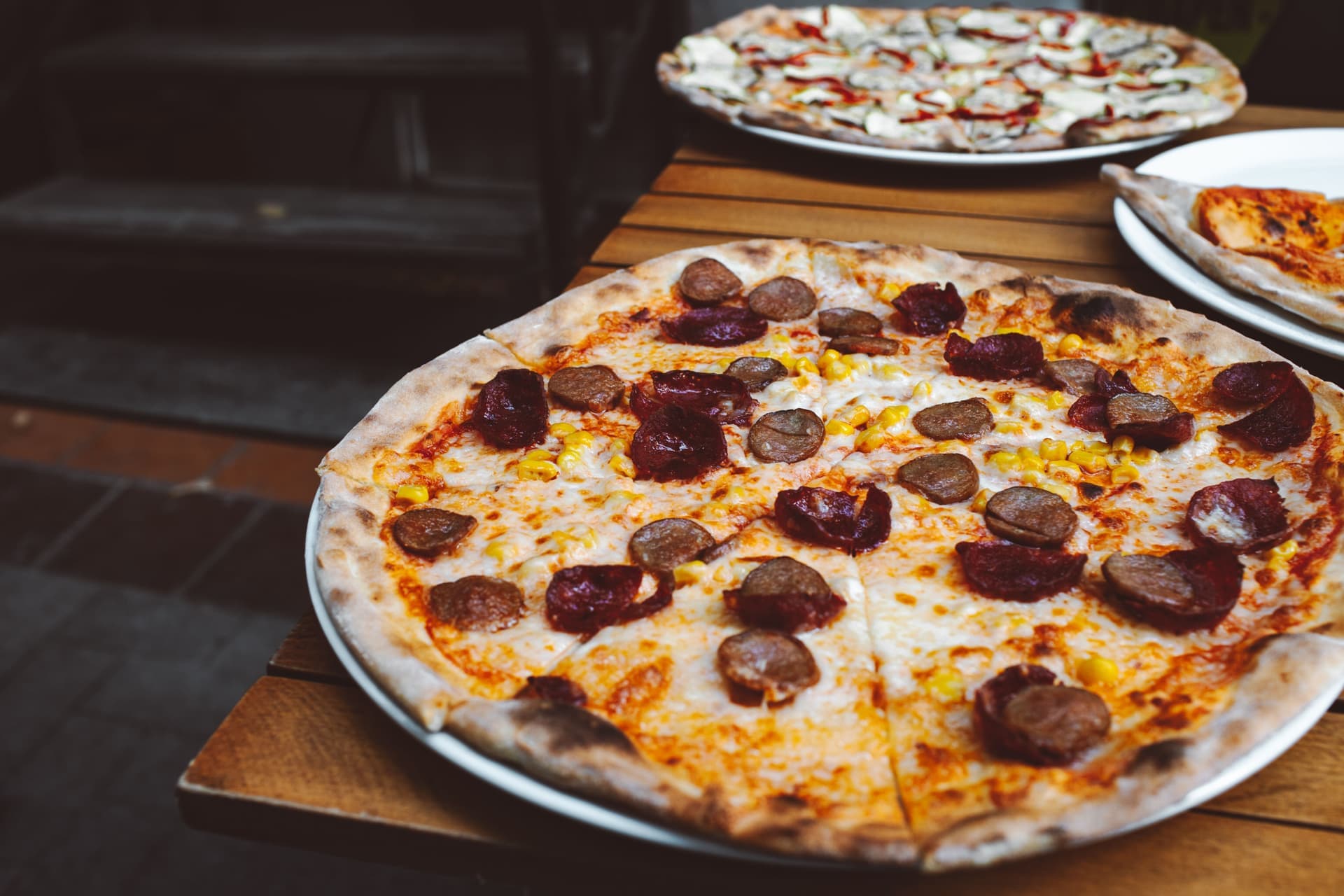 Pizzas on a wooden table outdoors