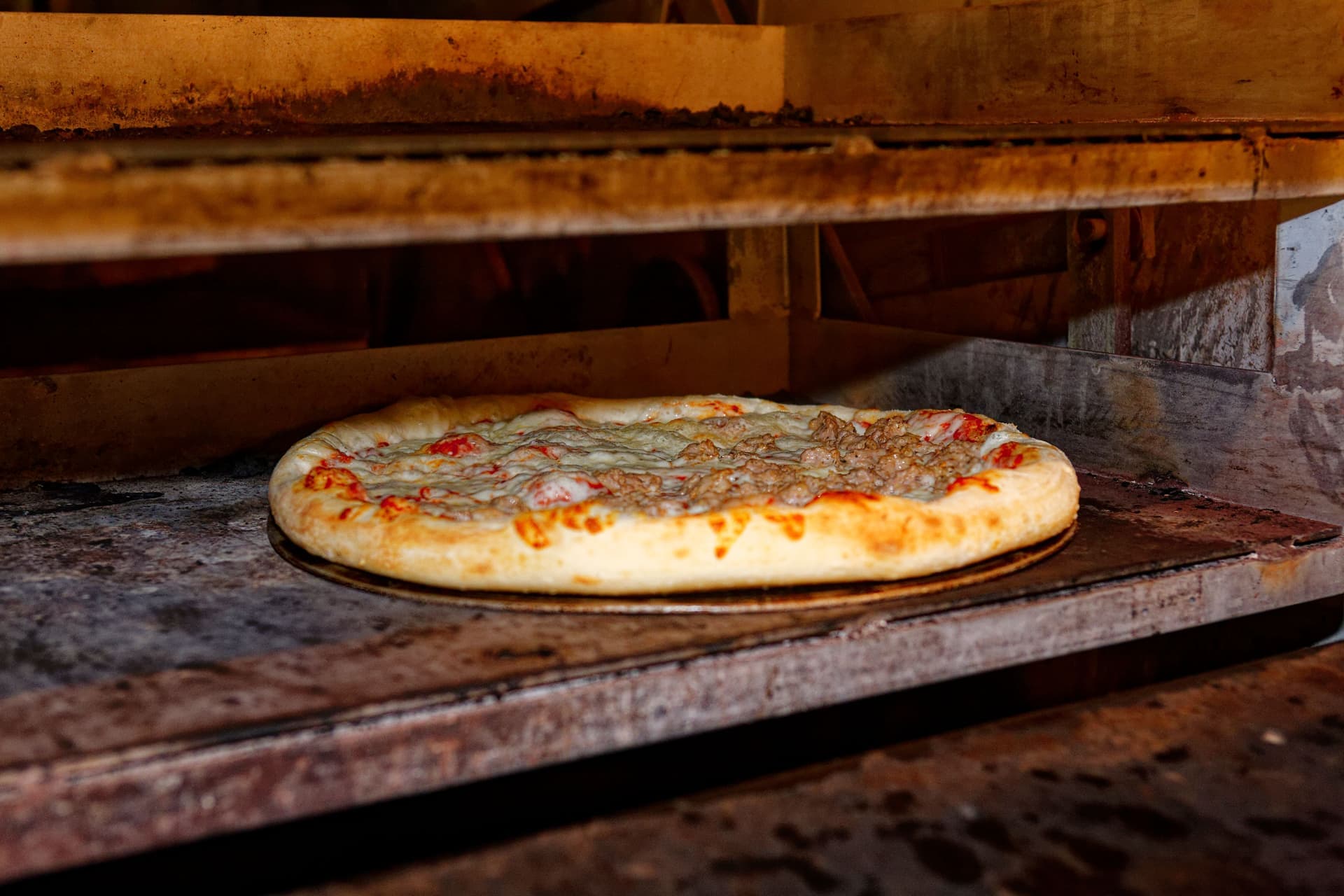 A pizza baking on a stone inside an electric oven