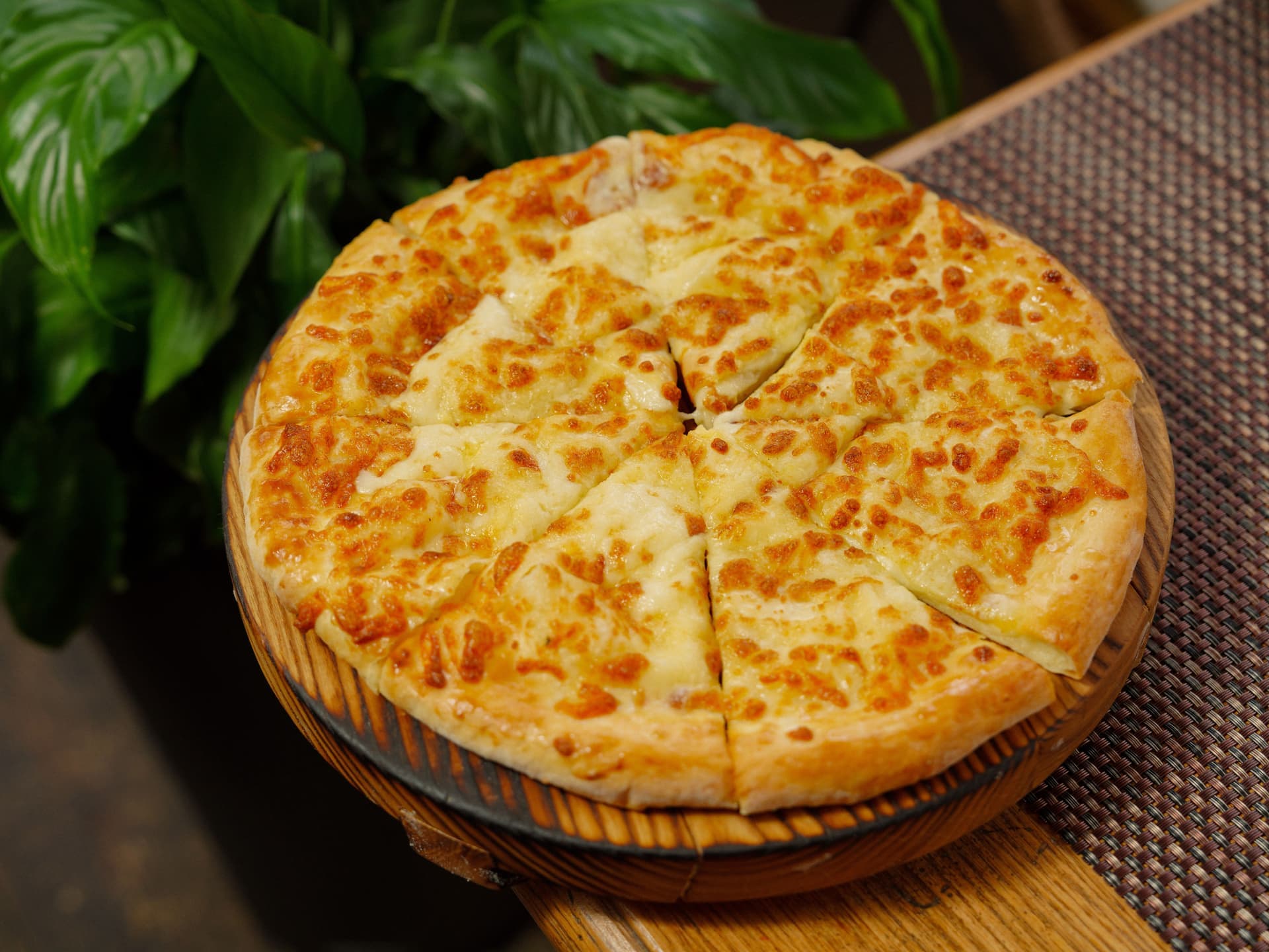 A cheese pizza on a wooden board