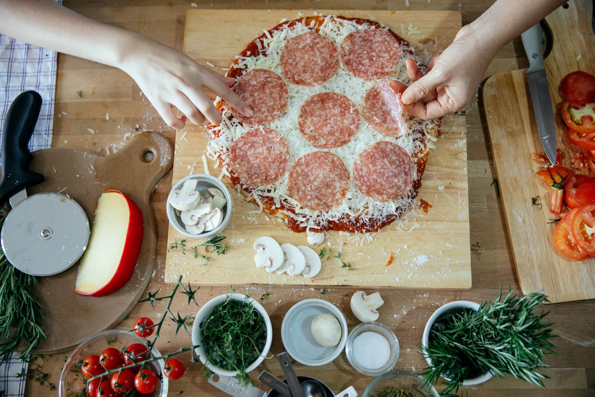 A pizza peel and oven tools laid out on a wooden kitchen surface