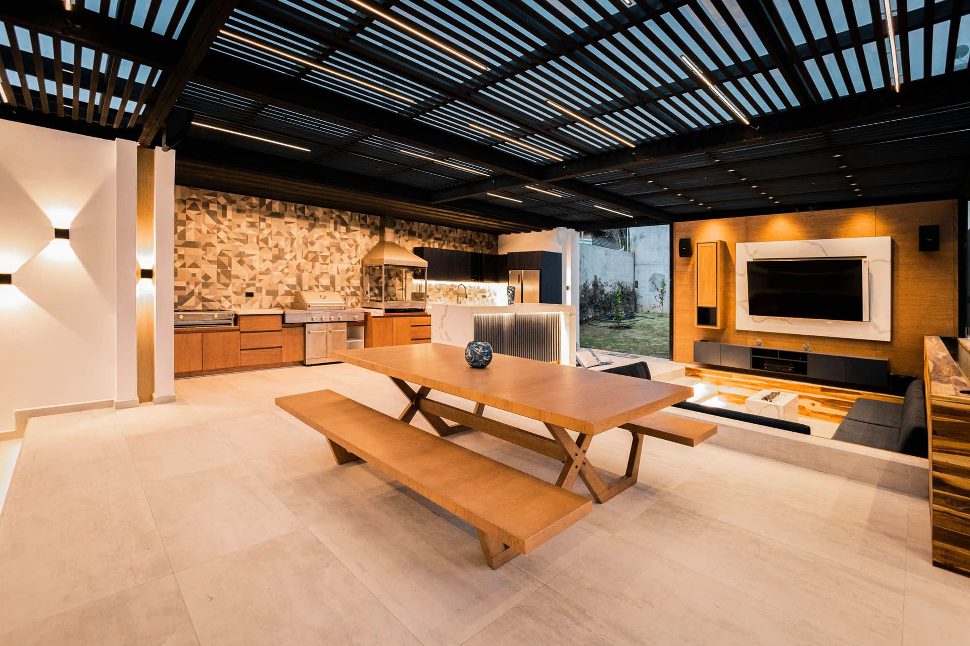 A covered outdoor kitchen with a built-in counter and grill