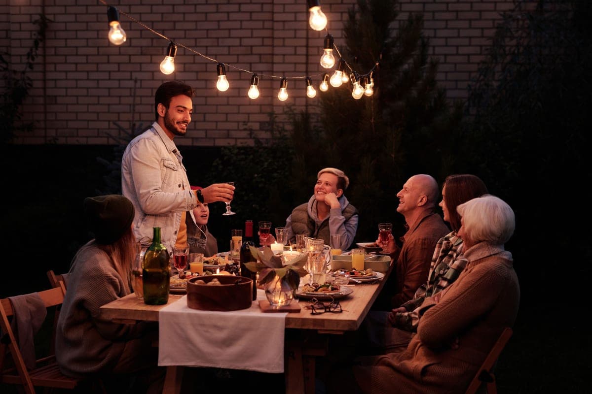 An outdoor dinner table set for a group in the evening