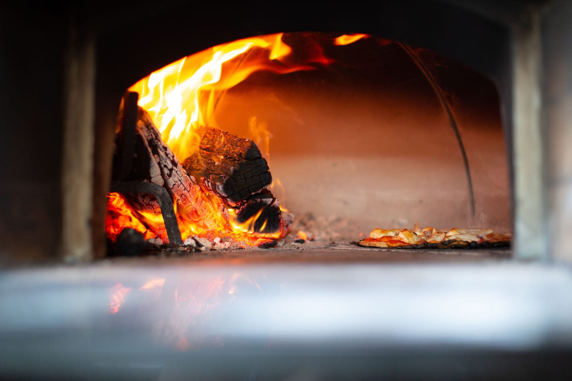 Flames inside a small wood-fired pizza oven